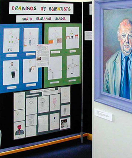 Scientist portrait alongside children's drawings in the exhibition